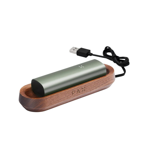 The Sage Pax 3 charging on the Wooden tray with the cable.