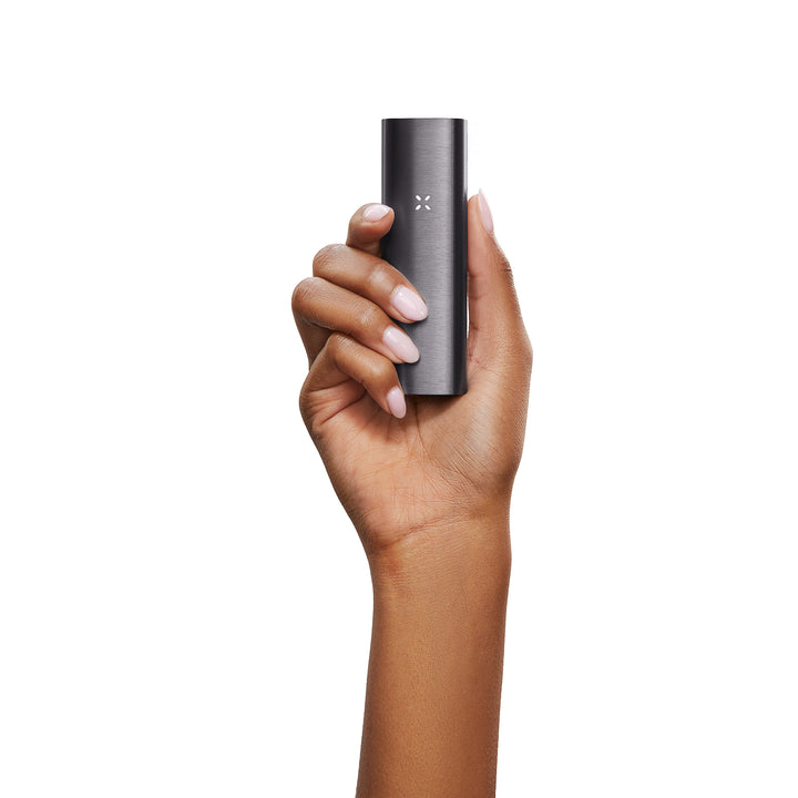 A womans hand holding the black Pax 2.